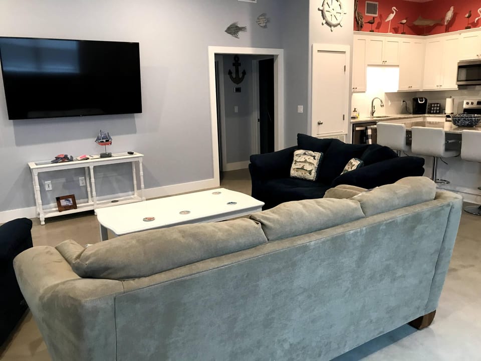 Living area with recliner, couch,  loveseat and 70" flat screen tv