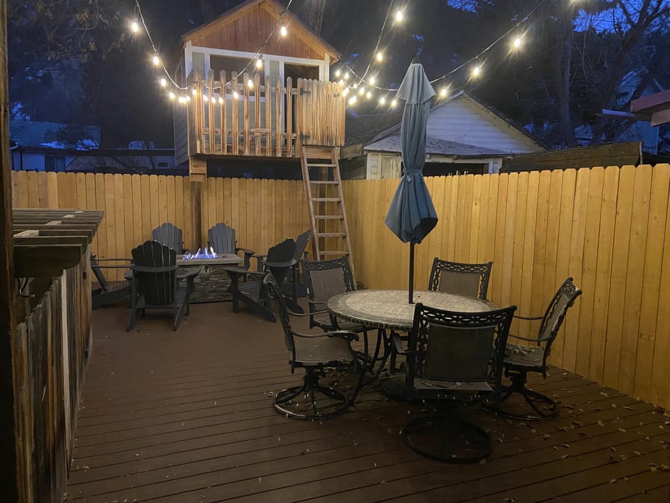 Adirondack chairs surrounding gas fire pit with additional outdoor dining area!