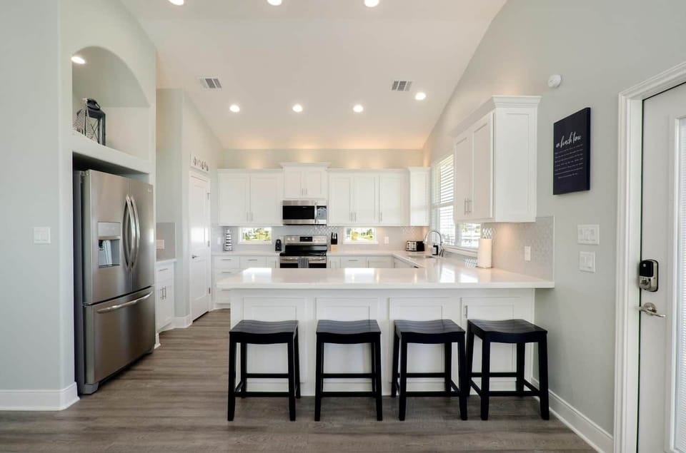Kitchen bar seats 4 with built-in trash bins for easy cleanup.