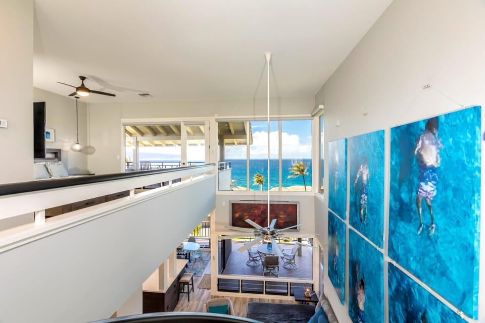 Dive into comfort beneath bold aquatic artwork and a statement staircase in this truly unforgettable lounge    