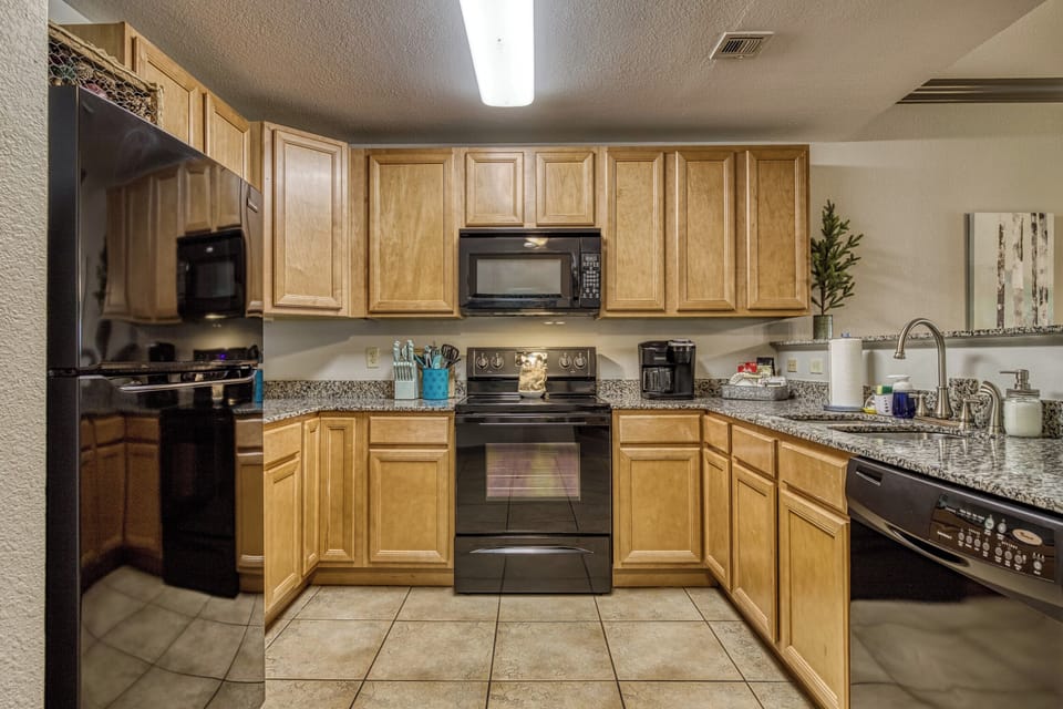 Fully stocked kitchen with granite counter tops & modern appliances for cooking
