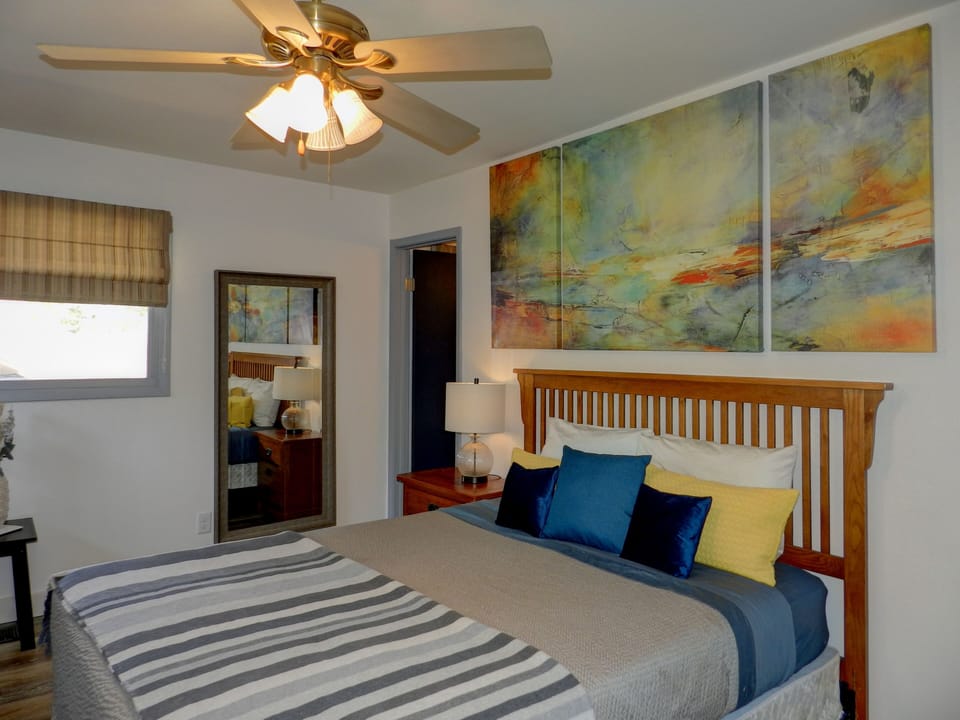 Master bedroom has a queen sized bed and full length mirror.
