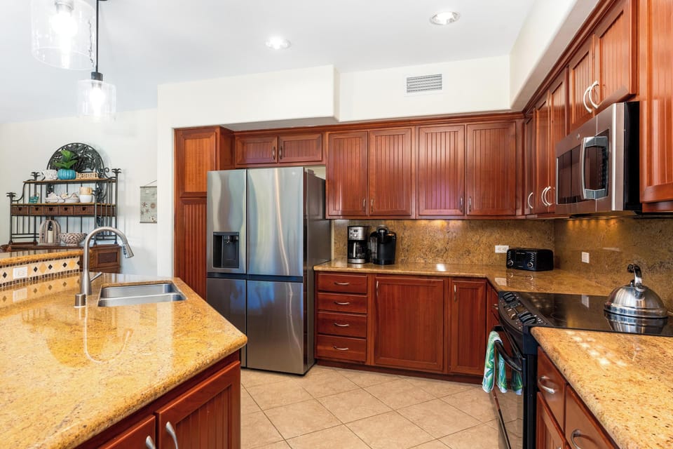 Fully stocked kitchen with granite countertops and stainless steel appliances