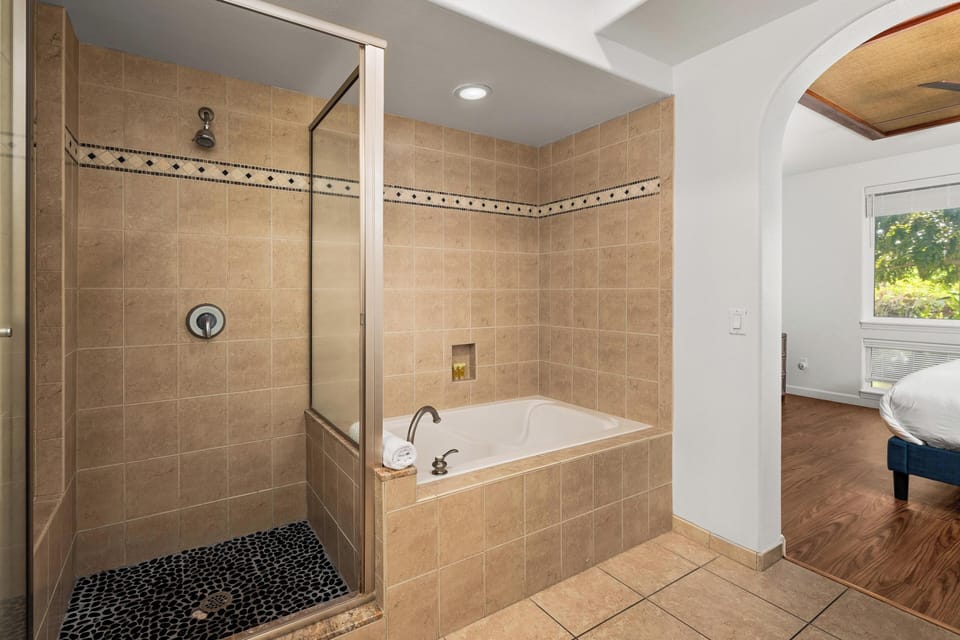 Ensuite primary bathroom with double vanity, walk-in shower, and tub