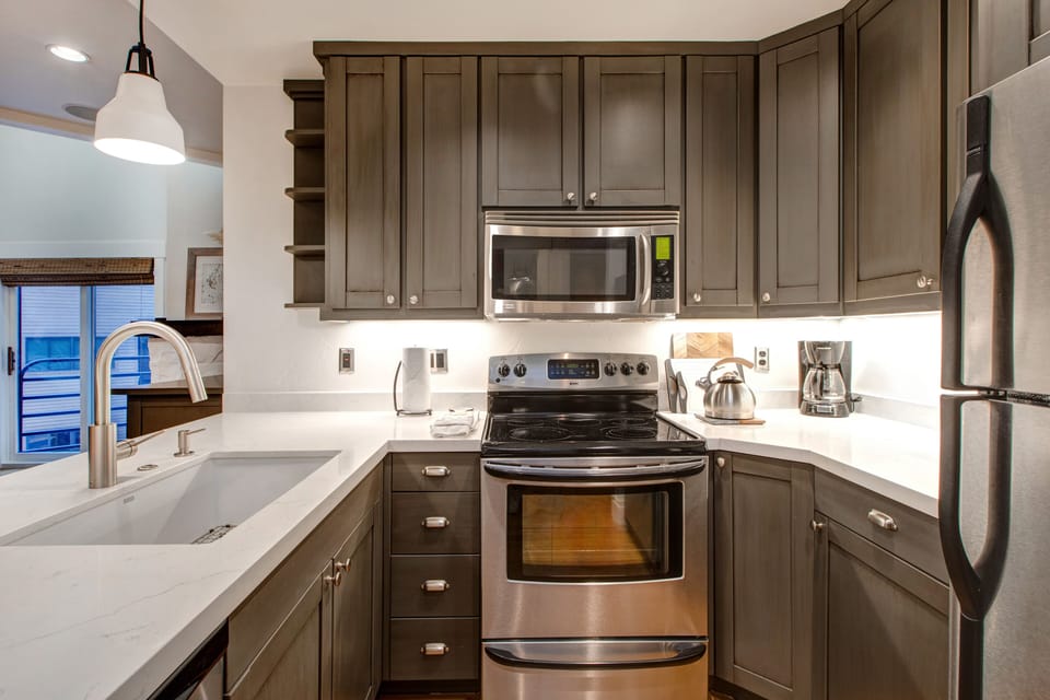 Fully Equipped Kitchen with gorgeous stone countertops, stainless steel kenmore appliances, and bar seating for four