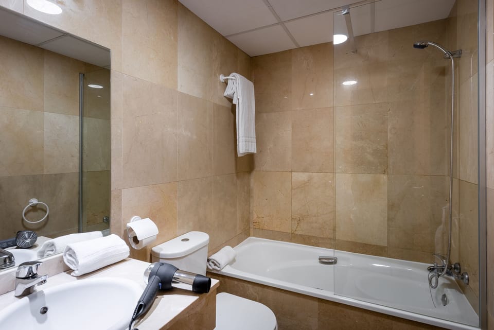 Bathtub, hair dryer, slippers, bidet