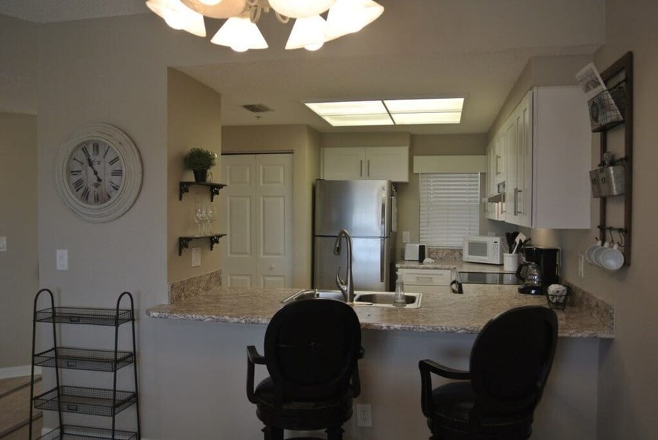 Well-equipped kitchen with modern appliances and breakfast bar seating.