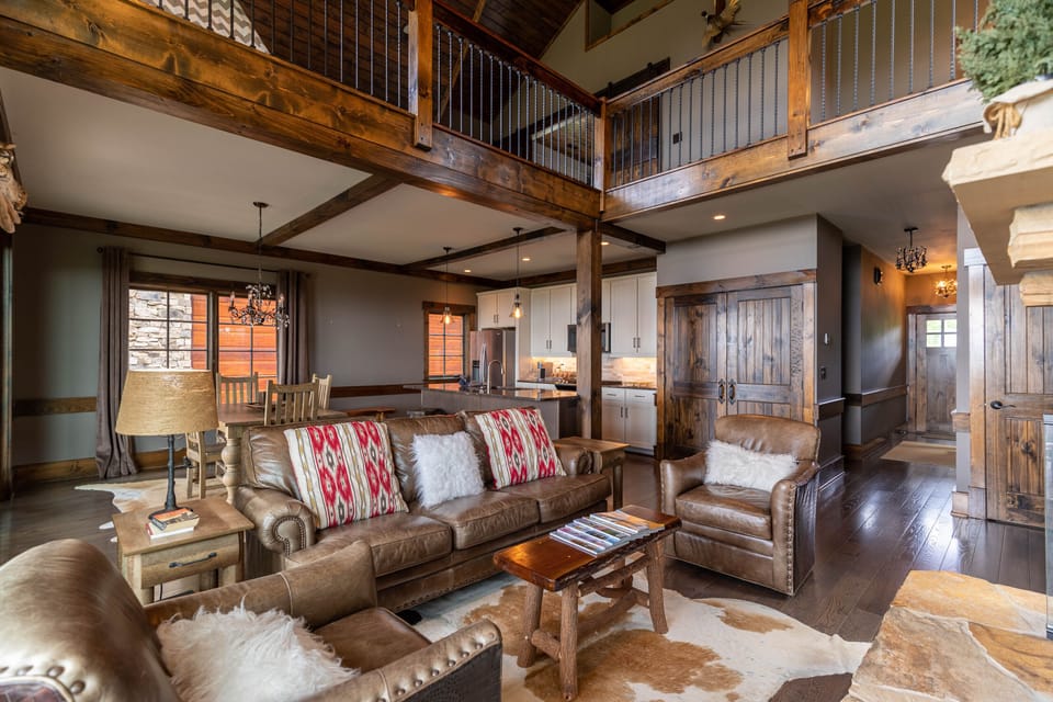 Soaring wood beams, leather sofas, and a cowhide rug set the tone for mountain living at Sunrise Lodge At Eagles Nest.