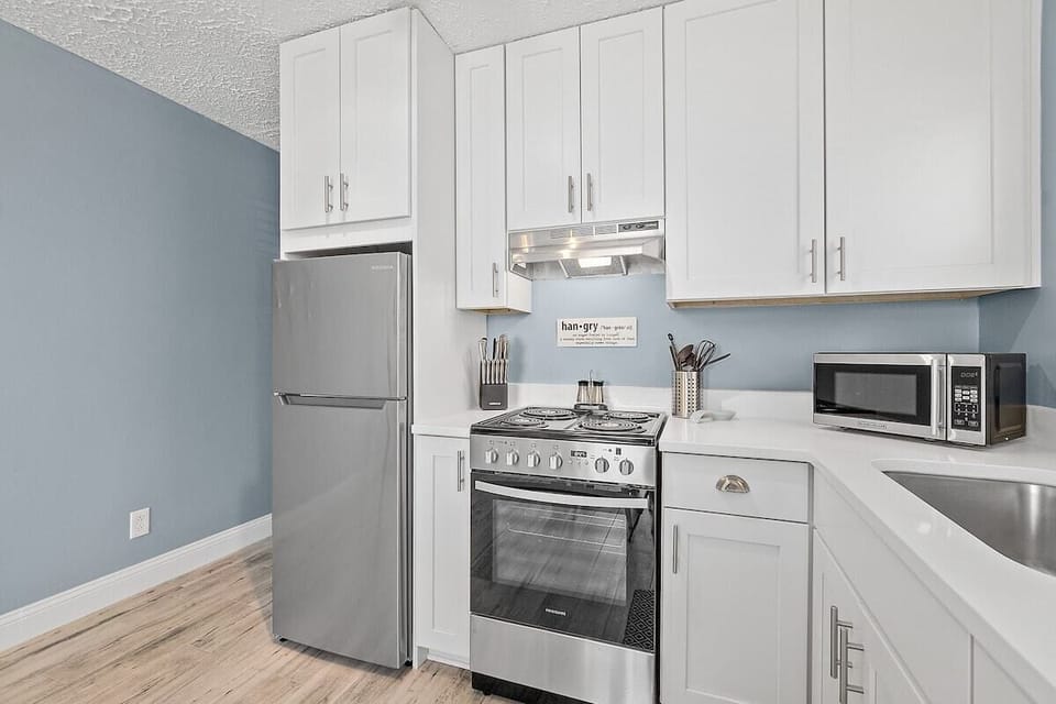 Refrigerator, stove and microwave in the fully stocked kitchen.