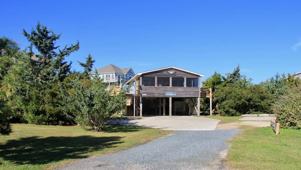 The beach house is set back from Colony Drive by a long gravel driveway