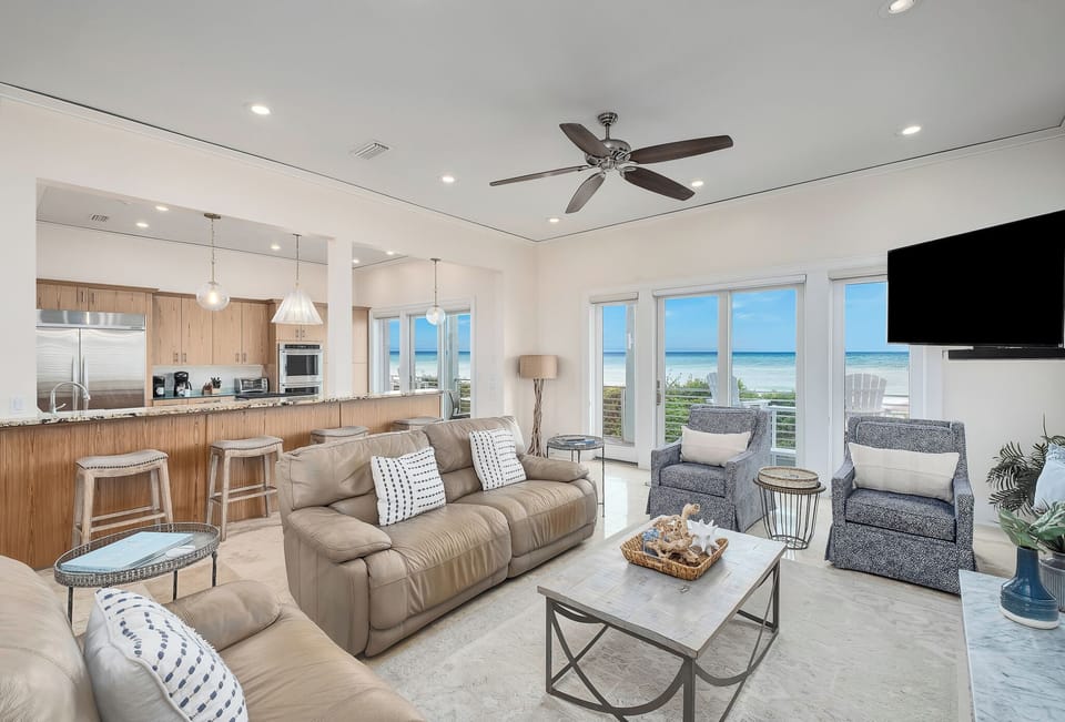 Relax in this bright, open living space with stunning ocean views through expansive windows. The comfortable seating and coastal décor invite you to unwind while enjoying the soothing sea breeze.