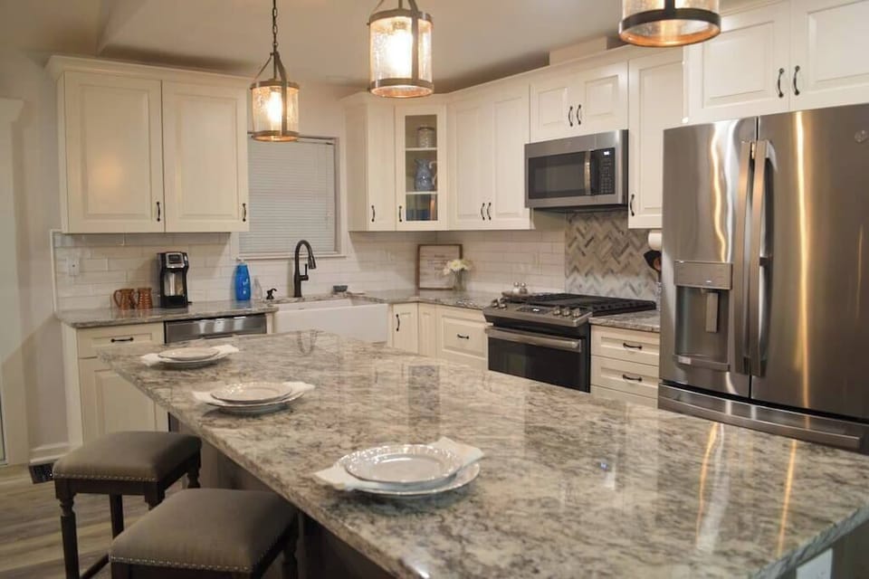A gas stove, stainless steel appliances and modern finishes give this kitchen its classic and comfortable feel.