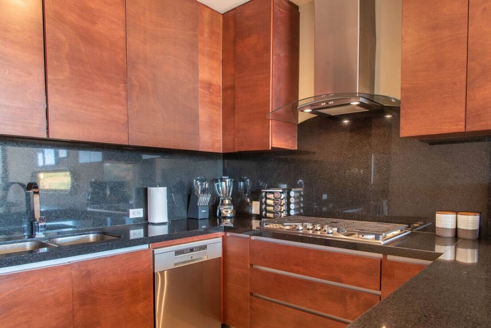 Sleek, modern kitchen area with a view, complete with all cooking essentials.