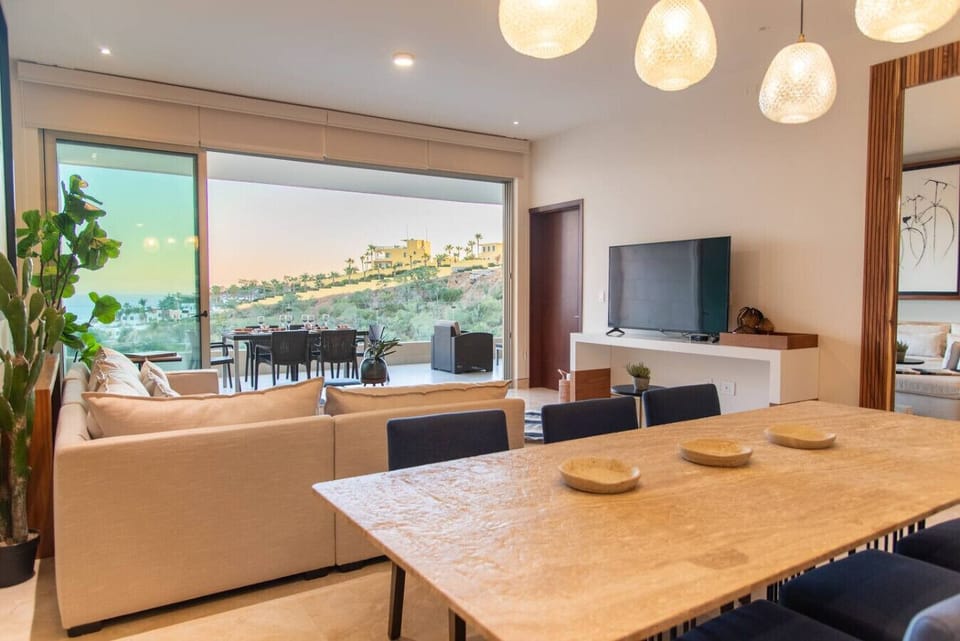 Living area with floor-to-ceiling windows, offering panoramic hillside views.