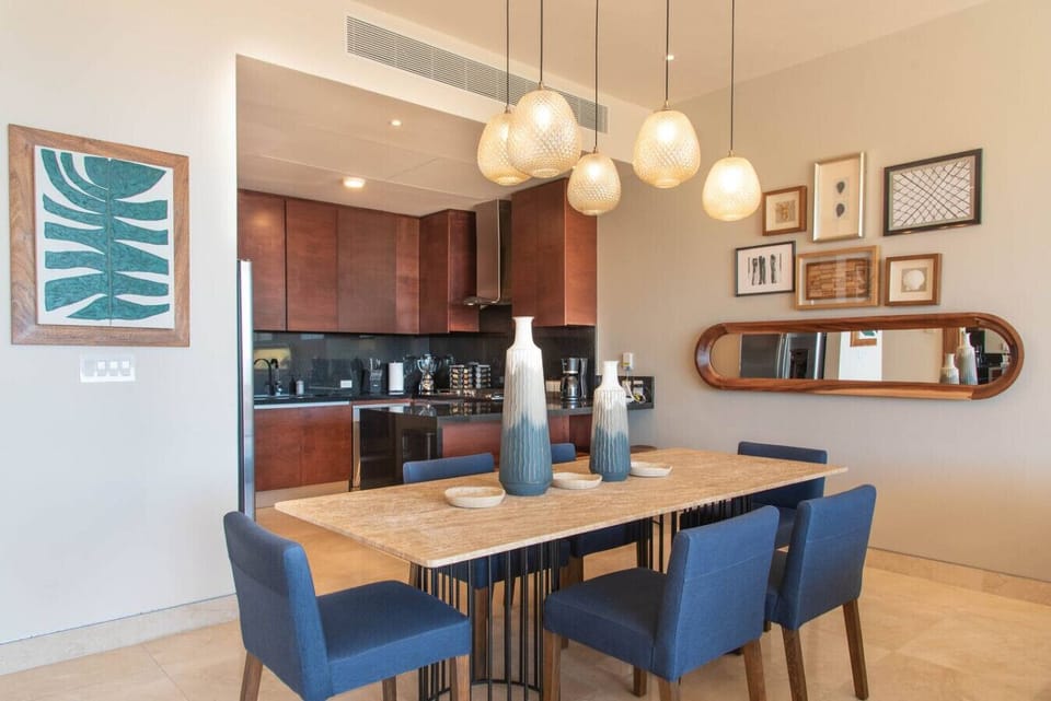 Dining area with elegant lighting, next to the kitchen for easy meal service.