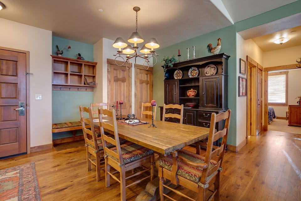 Gather around this charming wooden dining table where warm lighting and rustic decor create the perfect atmosphere for your memorable meals.