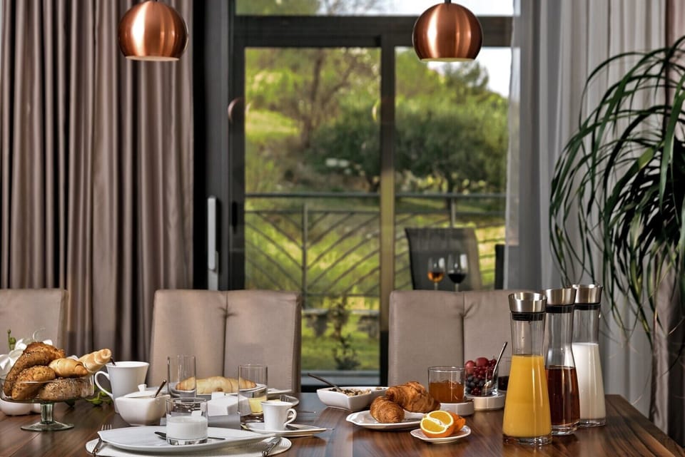 Breakfast served on the wooden dining table on the ground floor of the luxury villa Happiness and exit to the courtyard of the villa
