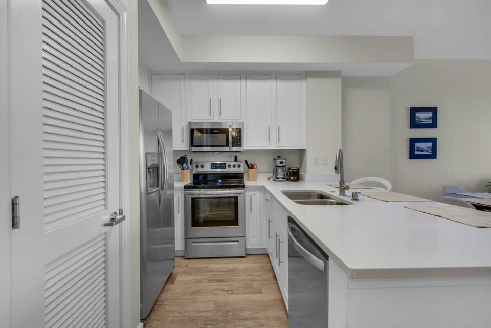Gourmet kitchen equipped with blender, coffee machine, lots of cookware, and enough dishes and dining utensils for everyone.