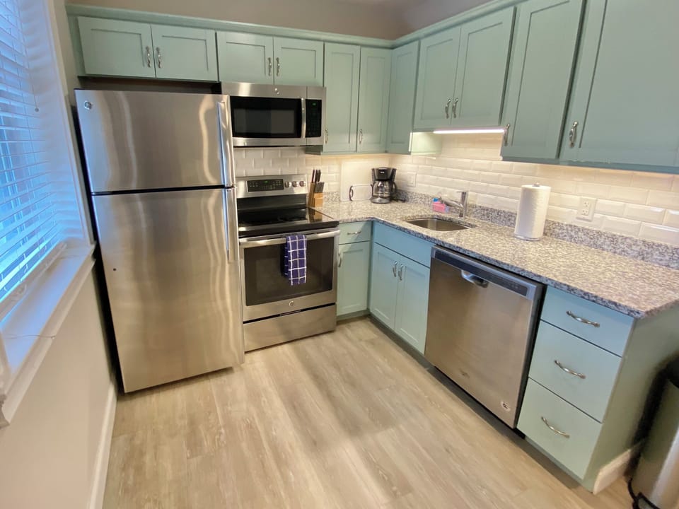 Kitchen with granite countertops & stainless dishwasher, refrigerator, stove.