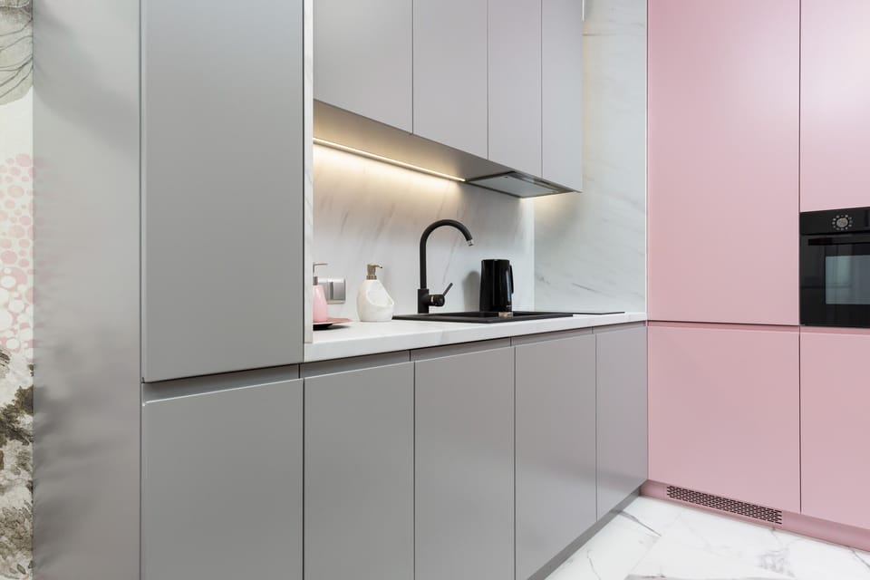 A closer look at the gray and pink kitchen area with a clean, minimalist style and functional design.