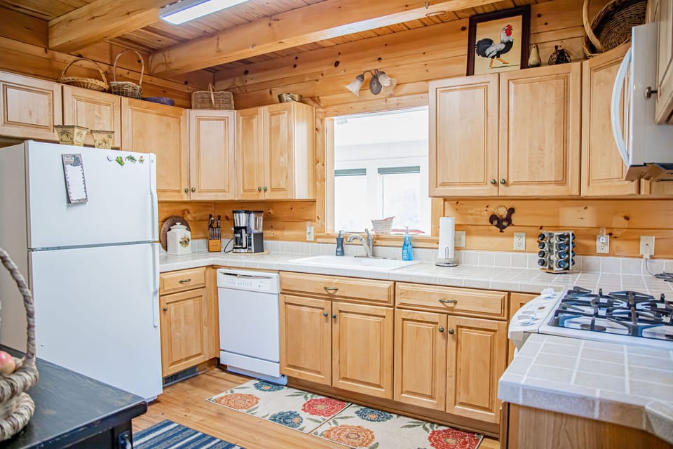 Kitchen fully stocked with all appliances and dishes for cooking. 