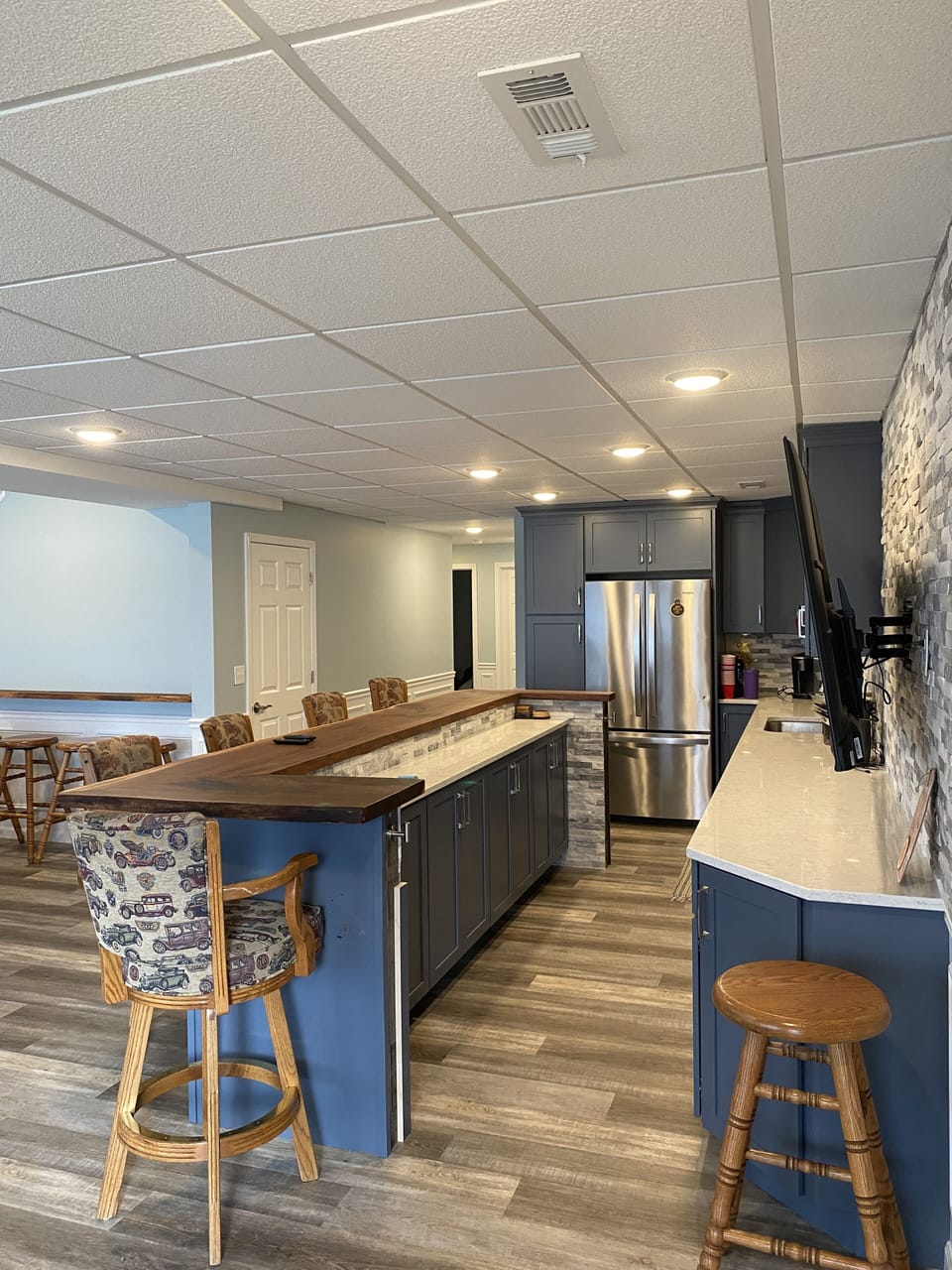 Walkout lower level wet  bar with wine cooler, ice maker and 65” TV