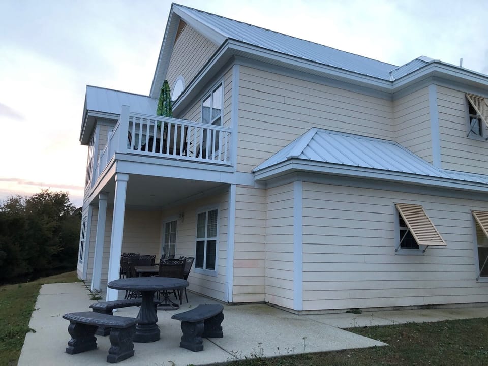 Back side of house with lower patio, and upper deck