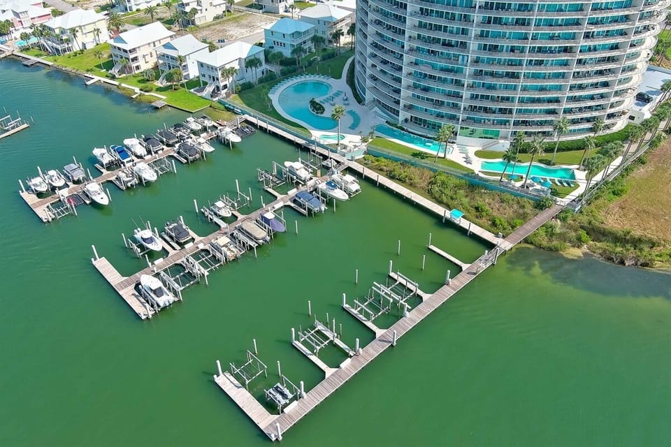 A serene marina scene unfolds, with the vast expanse of the Gulf of Mexico providing a breathtaking backdrop. The gentle rhythm of the bay meets the boundless energy of the open sea.