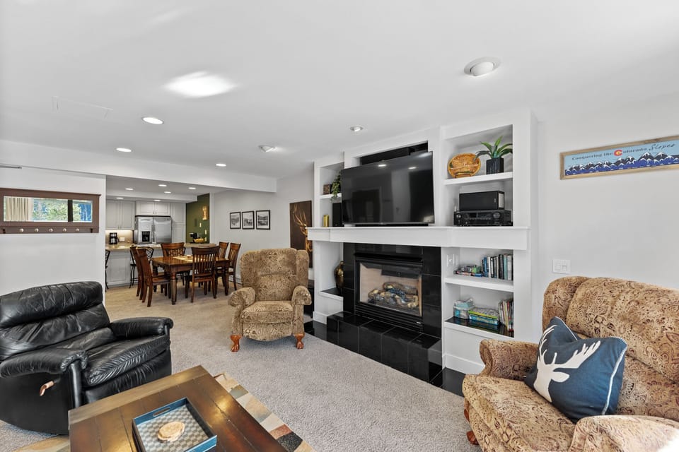 Cozy up by the fireplace in this inviting living space, where comfortable seating and warm lighting create the perfect atmosphere for relaxation.
