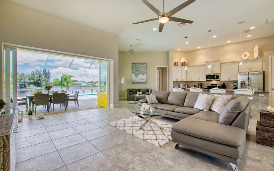 Open-concept great room with large sectional sofa and kitchen in background