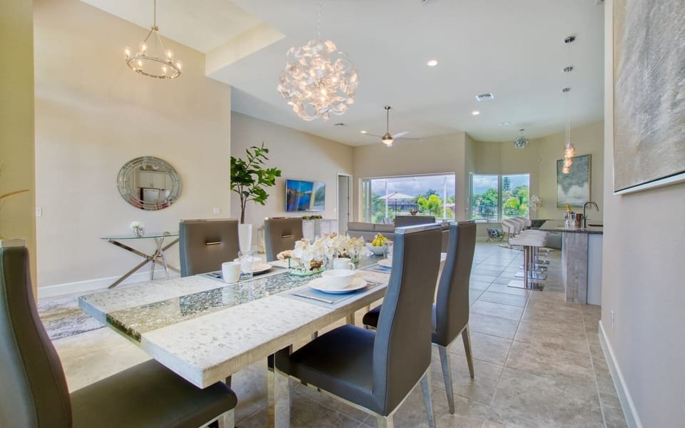 Bright dining area with circular chandelier and large sliding glass doors