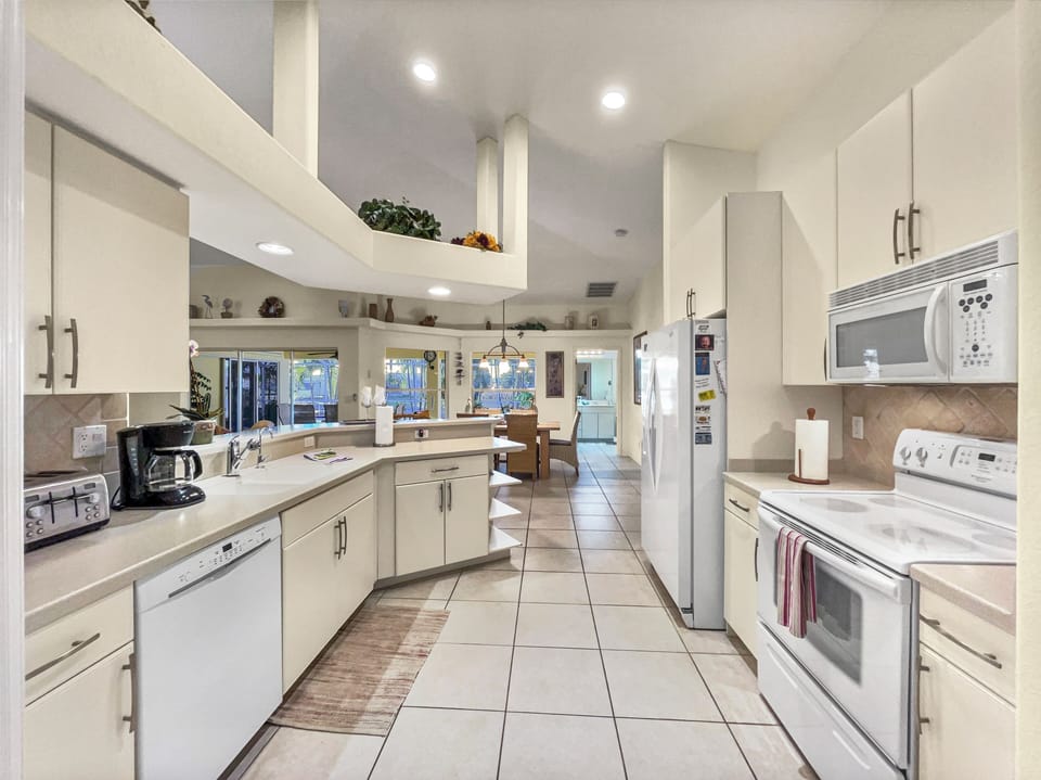 Kitchen with white cabinetry, stainless appliances, and tile flooring