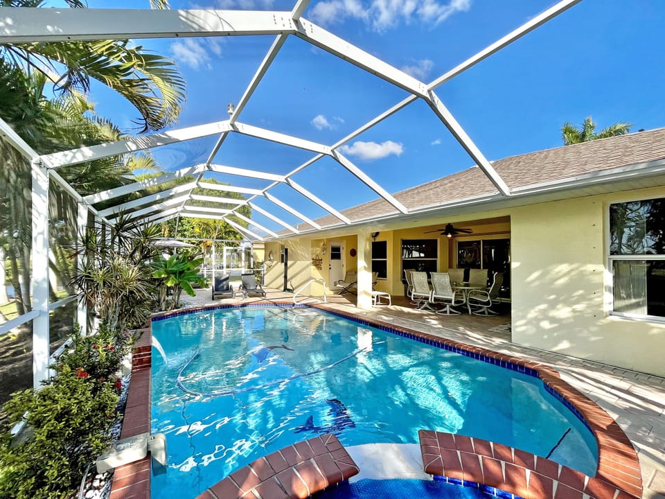 Pool and screened enclosure with the home exterior visible in the background