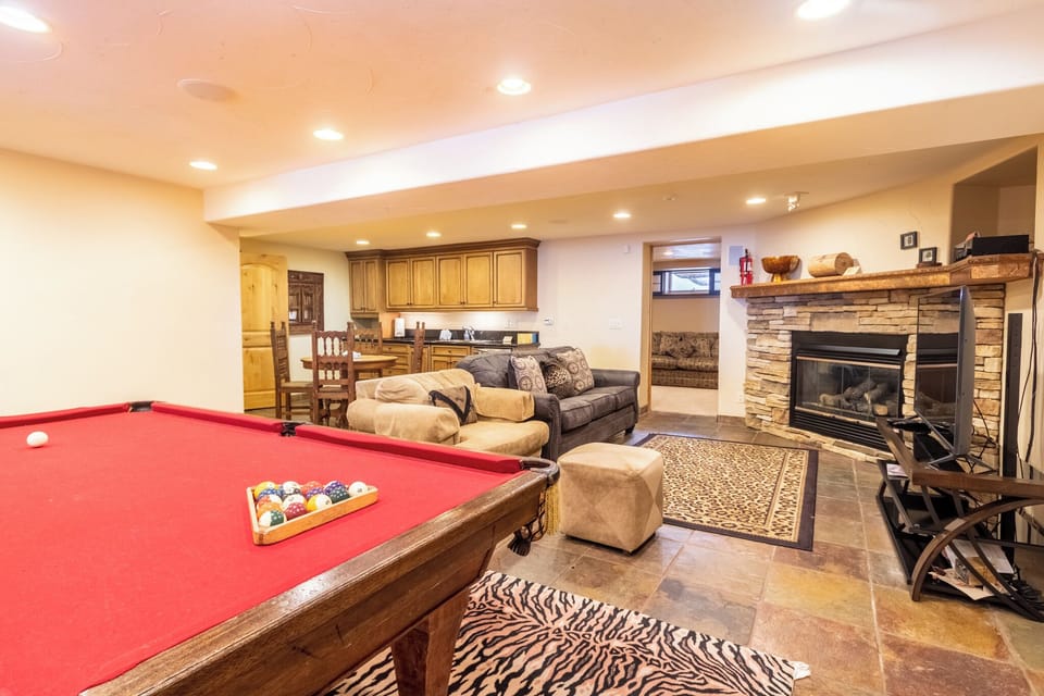 Your private basement retreat combines cozy comfort with endless entertainment—sink into plush seating by the fireplace or challenge friends to pool.