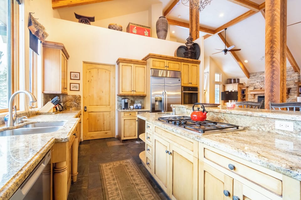 You'll love cooking in this spacious kitchen with granite counters, stainless appliances, and rustic timber beams overhead.