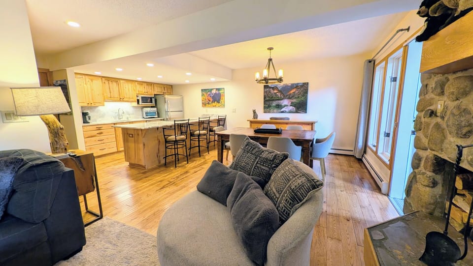 Living room, dining and kitchen area.  Door to right leads to deck, lawn & creek