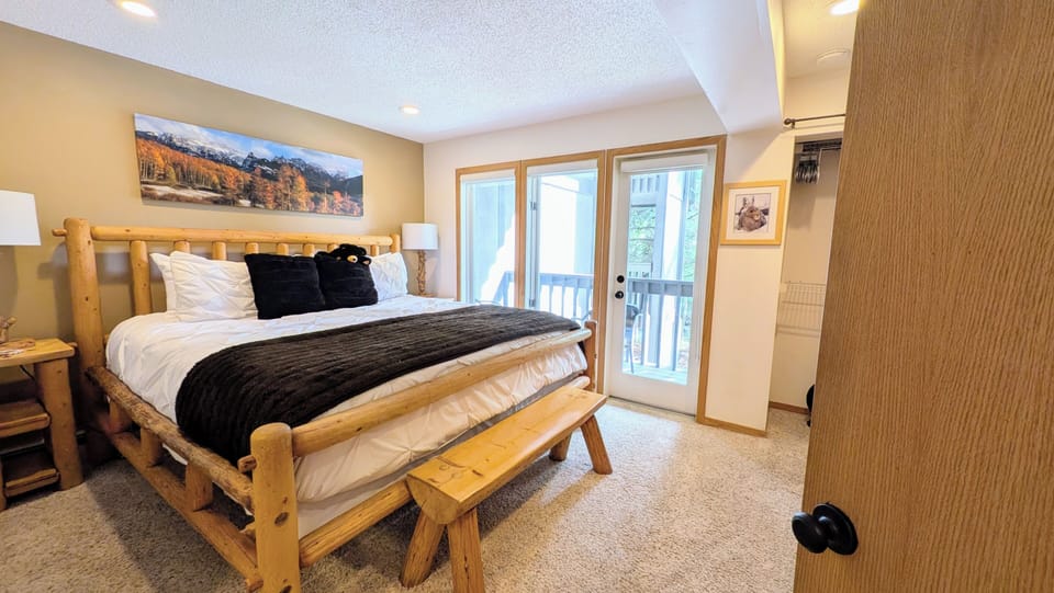 Primary bedroom, king bed, ensuite bathroom & deck overlooking Ten Mile Creek