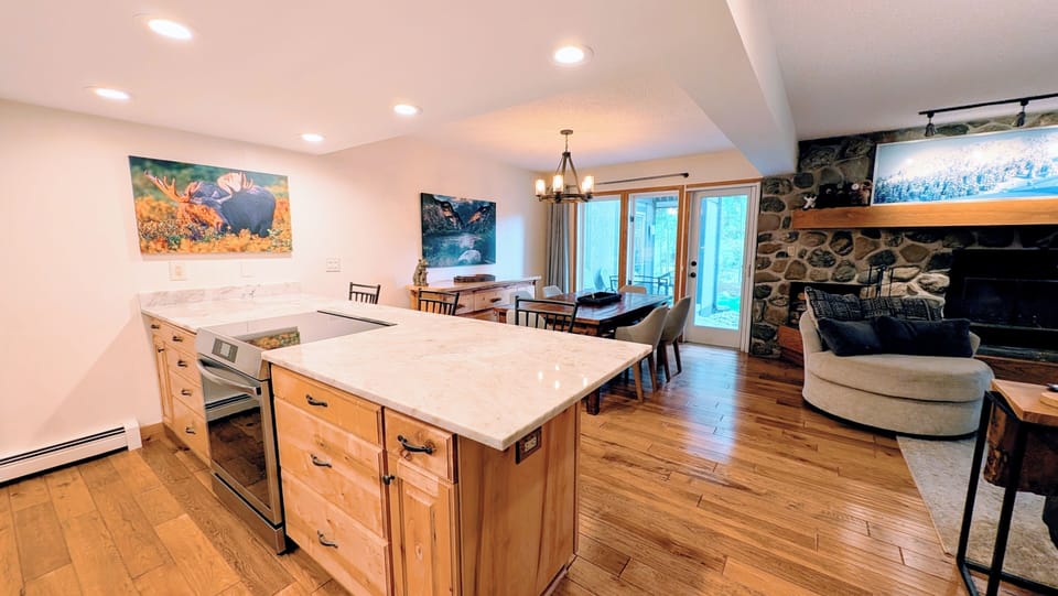 Modern kitchen, dining and deck area overlooking lawn and Ten Mile Creek