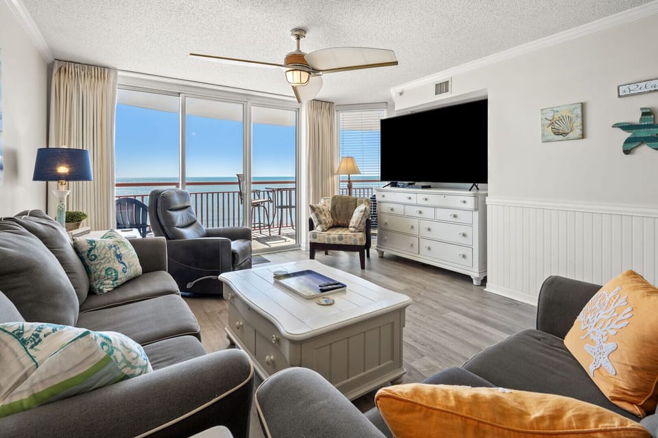 Living area with a sectional, TV and sliding doors to the ocean at South Shore Villas 701, Crescent Beach
