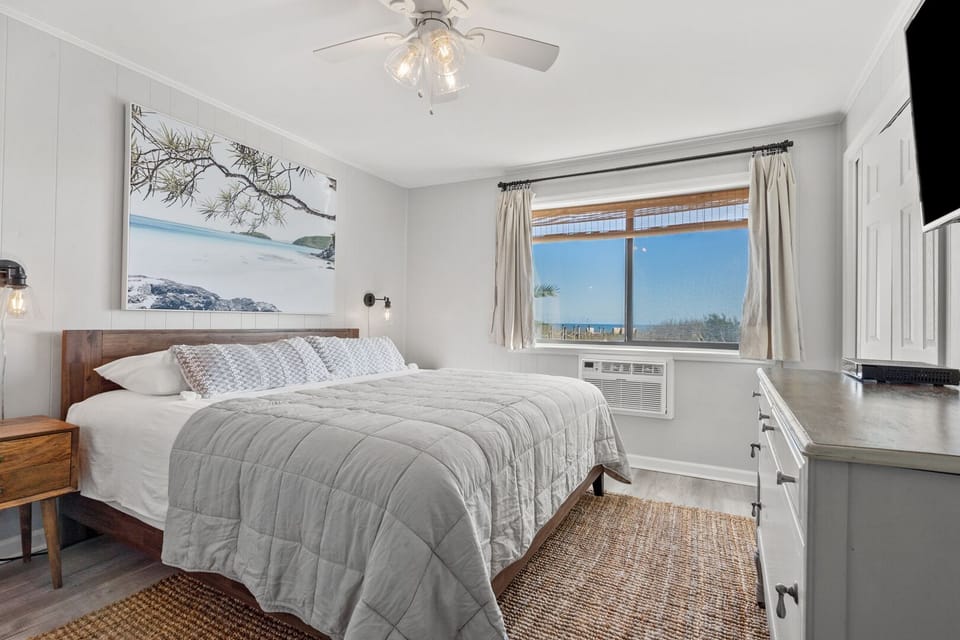 Bedroom with ocean views, a ceiling fan and dresser TV at Sun Villas A1, a 2-bedroom Crescent Beach condo