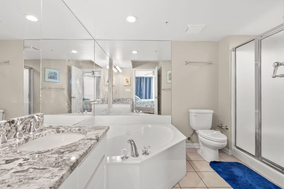 Bathroom with a wide mirror, tub and glass shower at Sunrise Pointe 11C, a Cherry Grove condo rental