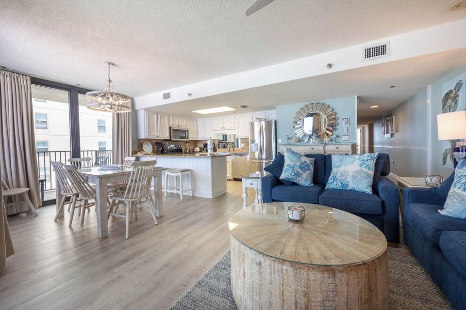 Relax in the inviting living area with plush seating, a stylish coffee table, and a view of the dining space