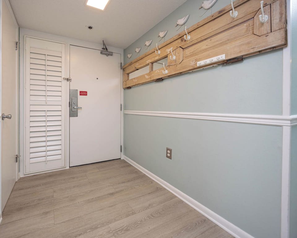 Step into a welcoming entryway featuring stylish hooks for your belongings and a light, airy color palette