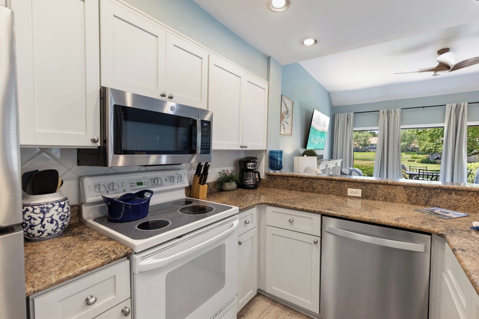 Your bright, fully equipped kitchen features stainless appliances, granite countertops, and a sunny breakfast area overlooking lush greenery—perfect for preparing memorable meals together.