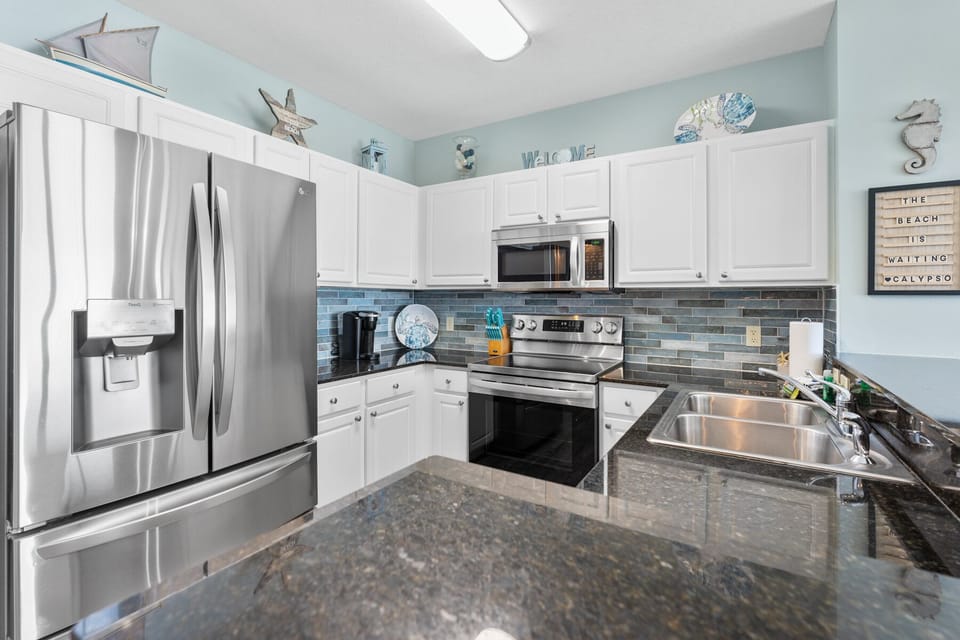 Your fully equipped kitchen features stainless steel appliances and coastal charm, perfect for preparing meals with ocean-inspired touches throughout.