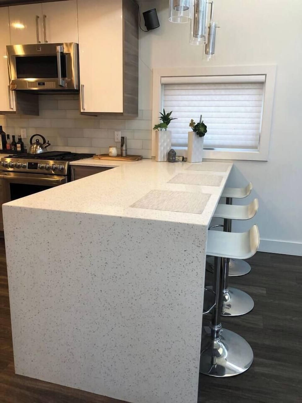 large kitchen island with seating and waterfall quartz solid surface