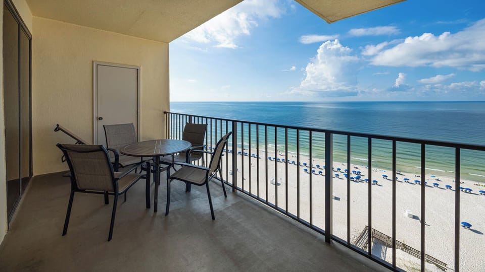 Relax on the private balcony with a table and chairs, offering breathtaking views of the serene beach and tranquil waters