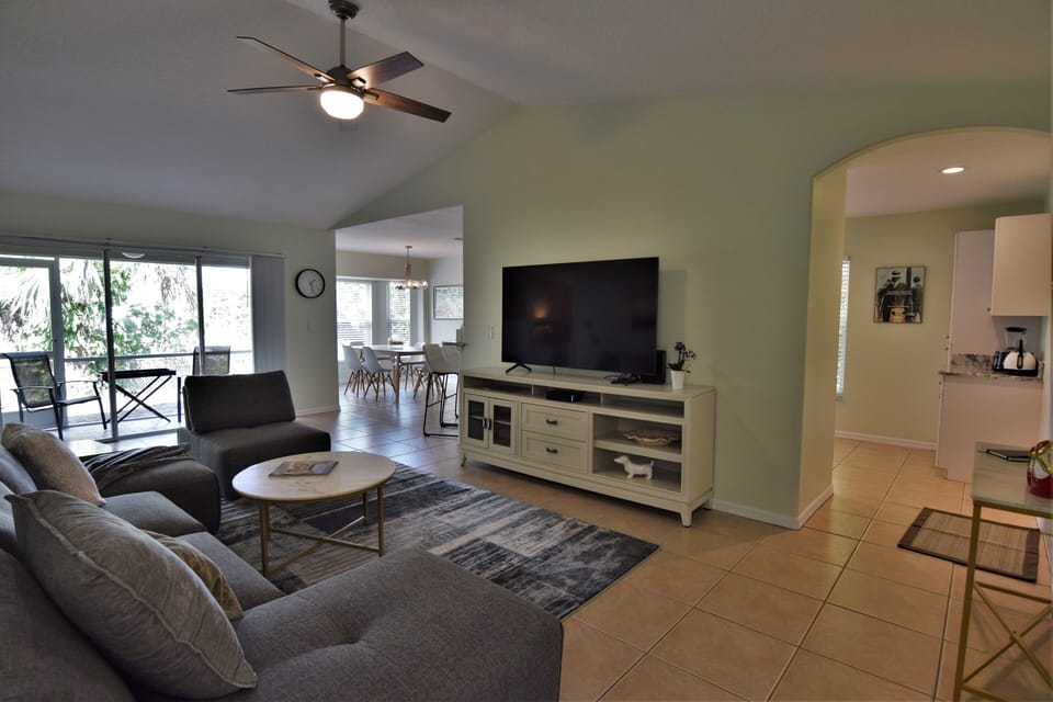 Living room with 65" TV  overlooking kitchen and dining room