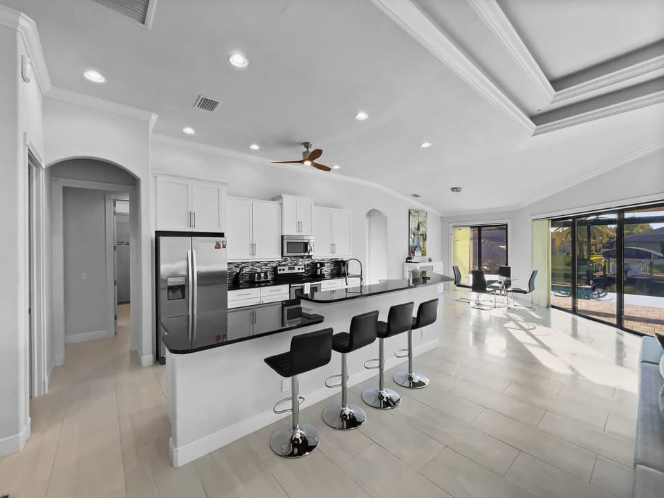 Kitchen with large island, bar seating, stainless steel appliances, and tray ceiling