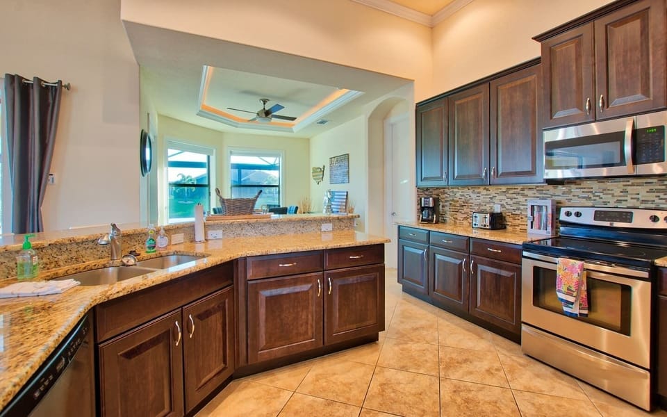 Kitchen counter area with stainless steel range, tile backsplash, and dark wood cabinetry